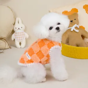 Close-up of orange checkered plush pet vest with D-ring and soft lamb wool texture