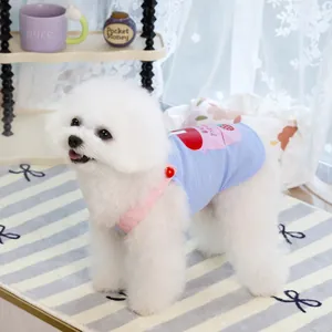 Dettaglio del gilet celeste per animali con stampa di fragole e bordo rosa su un cane bianco