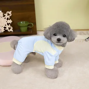 Close-up of light blue mesh pet jumpsuit with yellow contrast trim on a gray poodle