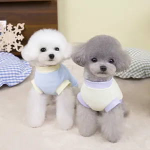 Two small dogs wearing breathable mesh pet t-shirts in blue and yellow colors