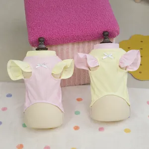 Pink and yellow ribbed knit pet vests with flutter sleeves and decorative white bows