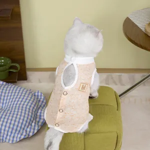 Detail of light orange knit pet vest with white collar and buttoned back cutout
