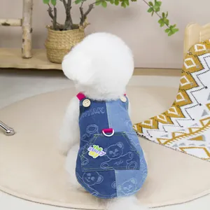 Detail of color-block denim pet vest with bear print, wooden buttons and pink webbing strap