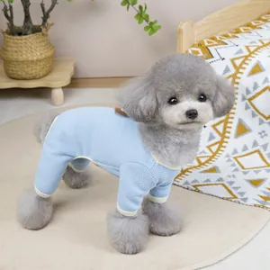 Blue waffle knit pet jumpsuit with cream trim shown on a small dog in home setting
