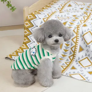 Close-up of green striped pet vest with cartoon dog patch on a grey poodle