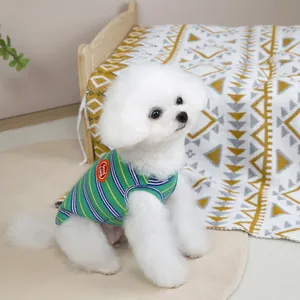 Dettaglio del gilet a righe verdi per cani con ricamo Good Luck su un piccolo cane bianco