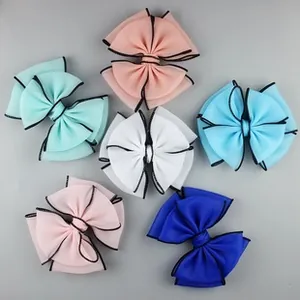 Macro detail of multi-color chiffon hair bows with premium black stitched edges