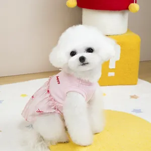 Close-up of pink ribbed pet dress with happy embroidery and red bow pattern details