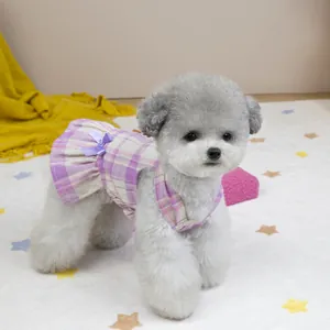 Detalle de un vestido para perro de cuadros morados con un lazo de seda suave