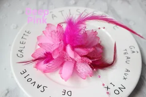 Dettaglio accessorio per capelli rosa scuro con piume, pizzo e decorazioni di perline