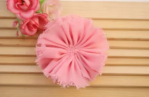 Detailed macro view of a handmade pink chiffon fabric flower with frayed edge texture