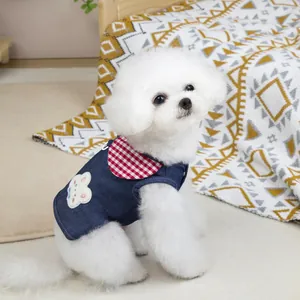 Dettaglio del gilet in denim per animali con colletto a scacchi rossi e ricamo di orsetto