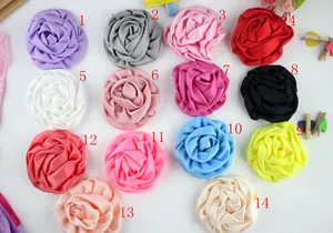Mise à plat de 14 accessoires de fleurs de rose en tissu coloré en diverses teintes mates