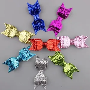 Flat lay of eight glitter leopard heart bow hair clips in vibrant assorted colors