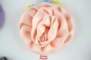 Détail de rose en tissu blanc cassé avec pétales superposés et pince en métal