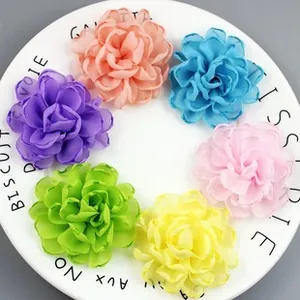 Detail of colorful chiffon fabric flowers with pearls in a white decorative tray