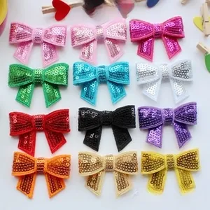 Macro shot of 12-color sequined glitter bows showing 5.5cm width measurement details