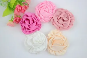 Vue détaillée de dessus de boutons de roses en tissu faits main en cinq couleurs
