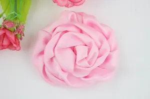 Détail d'une rose en tissu rose avec pétales superposés pour accessoires de mariage DIY