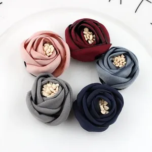 Detailed macro view of five colorful 5cm handmade satin rose flowers with stamen centers