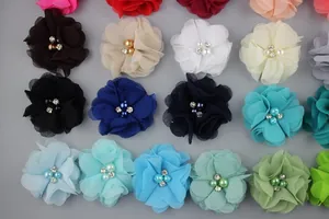 Macro detail of chiffon flower hair clips featuring pearl and crystal centers in multiple colors
