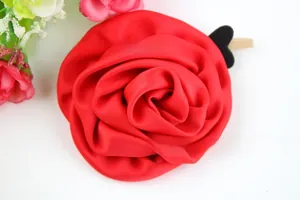 Détail d'un bourgeon de rose en satin rouge avec clip bois et support cœur noir
