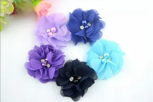 Detail of colorful chiffon flower hair clips featuring pearls and sparkling rhinestones