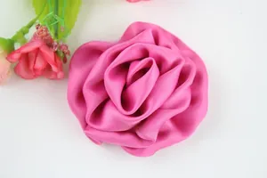 Gros plan d'une fleur faite main en satin rose avec des pétales soyeux multicouches