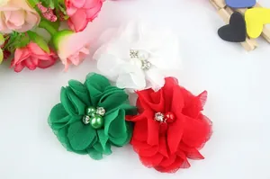 Detail of handmade chiffon flowers with pearl centers in white, green, and red colors
