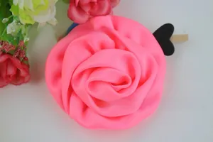 Détail de pince à cheveux rose en satin fait main avec clip cœur en bois à l'arrière