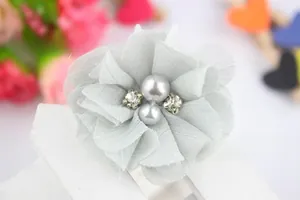 Detail of light grey chiffon flower hair clip with pearls and crystal rhinestones