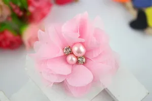Macro view of light pink chiffon flower hair clip with pearls and crystal rhinestones