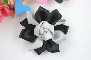 Gros plan sur une fleur de rose artisanale en ruban noir et argent avec éclat satiné