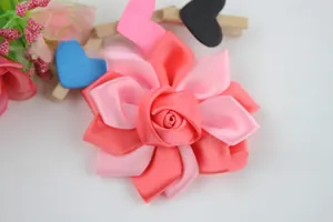 Vue détaillée d'une fleur faite main en ruban de satin avec des pétales de rose roses