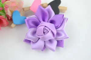 Détail d'un accessoire cheveux en forme de rose en ruban de satin violet fait main