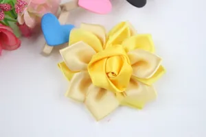 Détail macro d'une rose faite main en ruban de satin jaune pour accessoires de coiffure