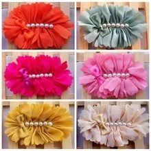 Detailed close-up of multi-layer chiffon flower hair clips with pearls and small ribbon bows