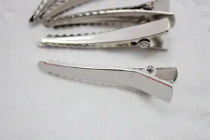 Détail de pinces à cheveux argentées en métal avec bords dentelés pour accessoires DIY