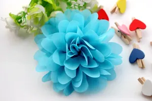 Detailed view of layered sky blue chiffon fabric flower with green leaves for hair accessories
