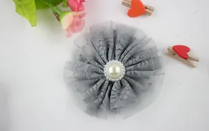 Detail of grey layered lace flower with mesh base and central faux pearl decoration