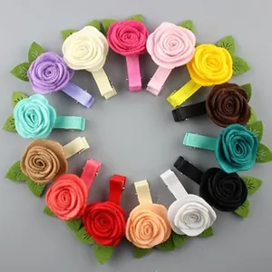 Flat lay of 14 colorful handmade fabric rose hair clips with green leaves for girls