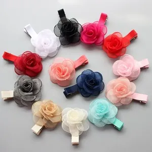 Detailed top view of 12-piece set of colorful organza rose flower hair clips on a grey surface