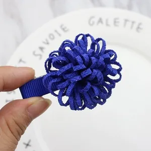 Detail of royal blue fabric flower hair clip with textured petals on a metal duckbill base
