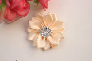 Detailed macro view of handmade champagne satin fabric flower with sparkling rhinestone center