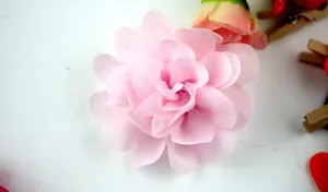 Macro-opname van handgemaakte roze chiffon bloem voor meisjes jurken accessoires