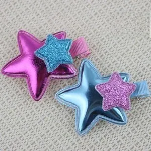 Close-up of star-shaped hair clips featuring layered metallic and glitter fabric stars