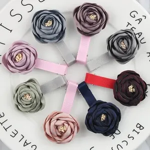 Detail of 8-piece set silk rose flower hair clips in various Morandi colors on a white plate