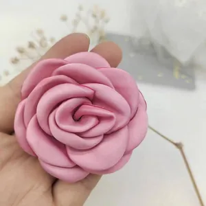 Close-up of pink satin camellia flower for hair accessories and DIY apparel decor