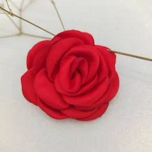 Detail of elegant red satin rose flower hair accessory with a soft silk texture