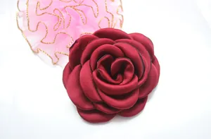 Macro shot of deep burgundy camellia flower with layered petals and black stitched edges